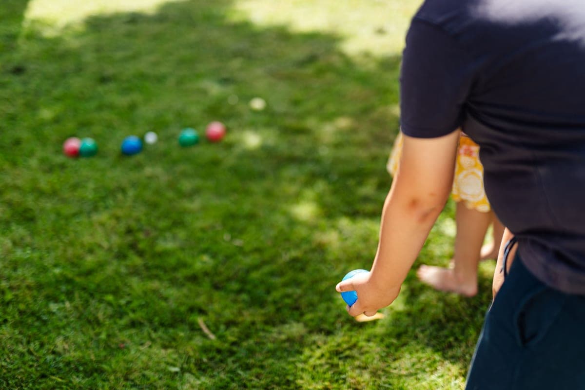 Bocce balls resting on a short grass lawn