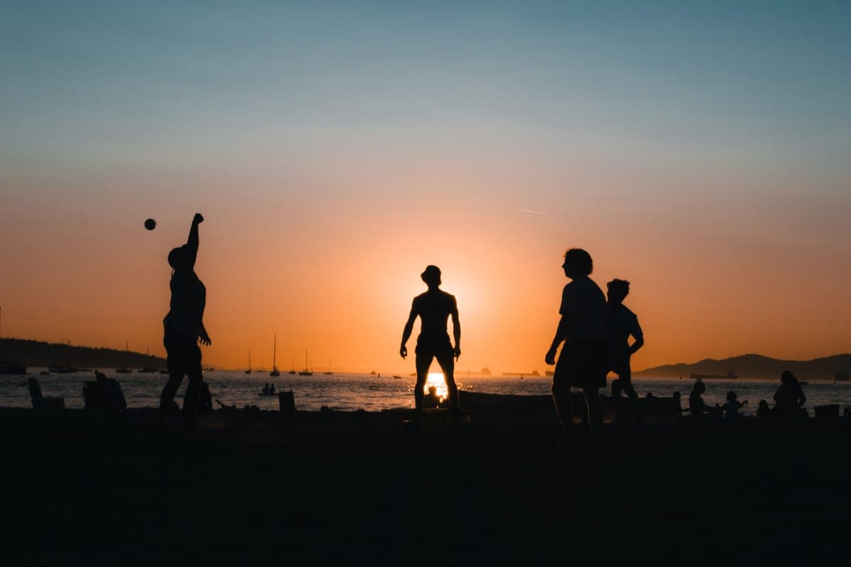 Players around a low circular net game on sand