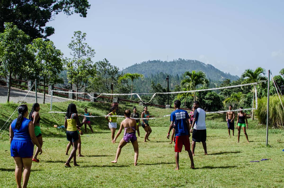 A net set up on a lawn with people playing